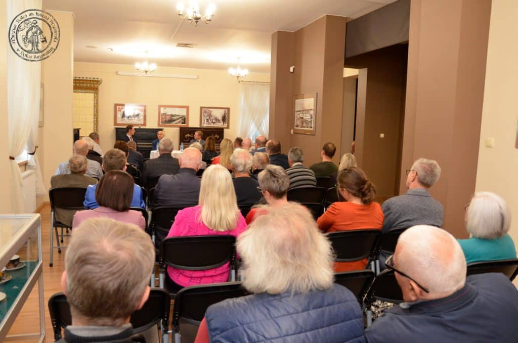 Otwarcie wystawy "Pamiętne eliminacje" w Muzeum Solca. Na pierwszym planie siedząca publiczność, dalej siedzą, od prawej: Rafał Kubiak, w środku Andrzej Strejlau, po prawej Łukasz Wojtecki.