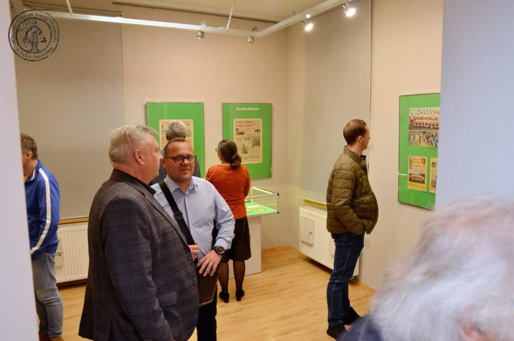Otwarcie wystawy "Pamiętne eliminacje" w Muzeum Solca. Zdjęcie przedstawia osoby oglądające antyramy i gabloty w mniejszej sali wystaw czasowych.