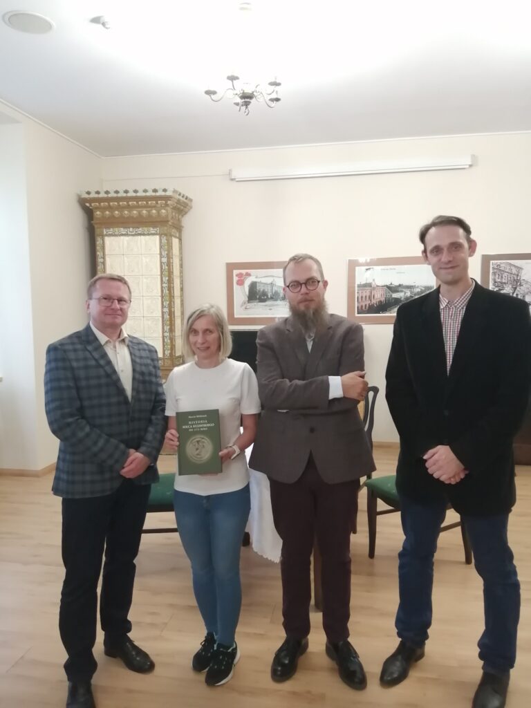 Zdjęcie przedstawia cztery osoby. Pracowników Muzeum Solca wraz z p. Marcinem Hlebionkiem na tle sali konferencyjnej Muzeum Solca.