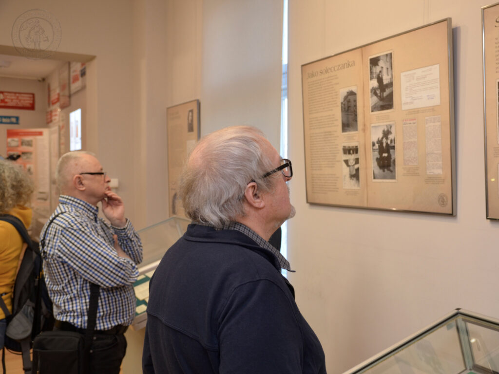 Dwóch mężczyzn ogląda plansze wystawowe.